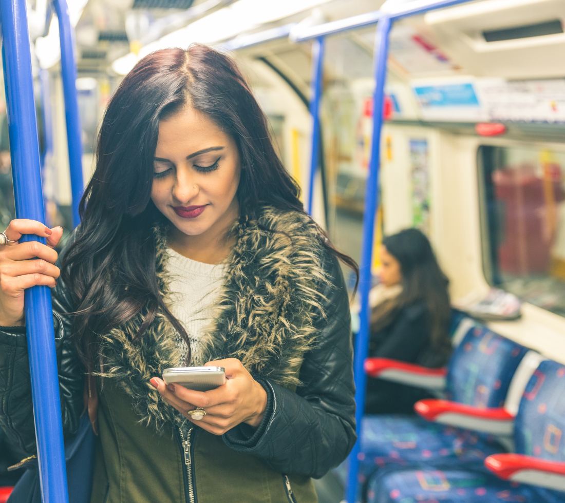 girl using smartphone on London Underground